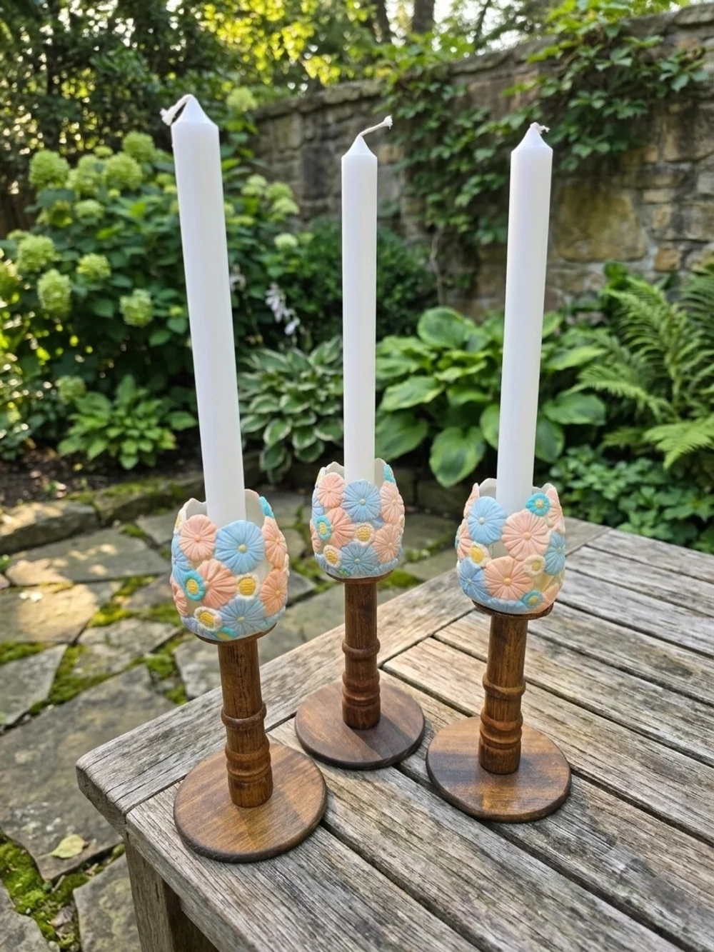 Trio Of Turned dark wood candlestick holders pastel-colored sculpted floral cups